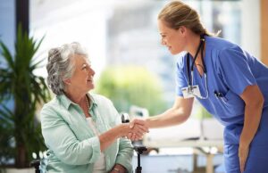 Family member and older resident talk quietly in a bright assisted living lounge.