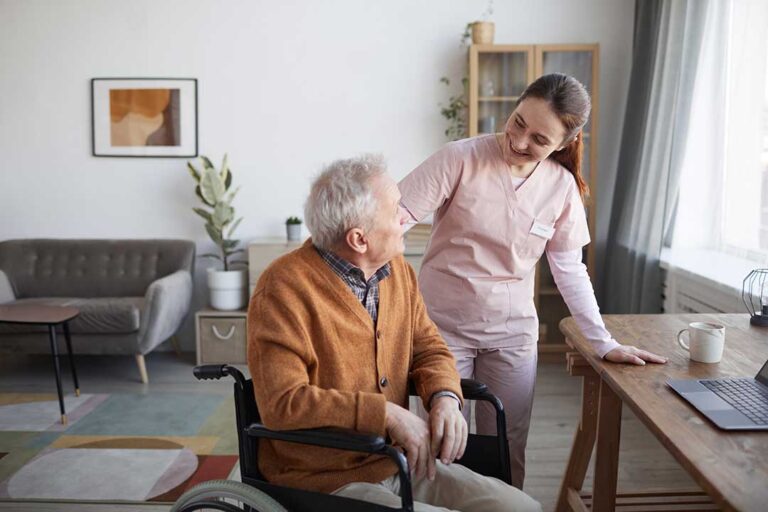 Adult daughter and senior woman sitting together on a couch, sharing a conversation and looking at a photo album.